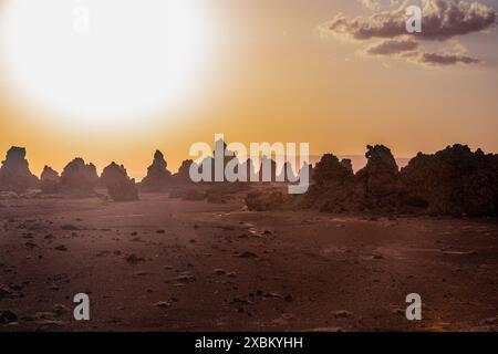 Moon landscape of limestone chimneys geological rock formations in a sunset rays at the bottom of dried salt lake Abbe, Dikhil region, Djibouti Stock Photo