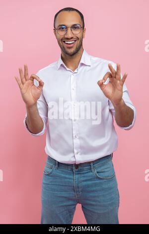 Satisfied man in white shirt showing okay gesture Stock Photo