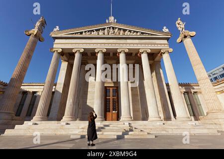 Tourists photographing the Academy of Athens, blue sky, neoclassical building from 1885, architect Theophil Hansen, Athens, Greece Stock Photo