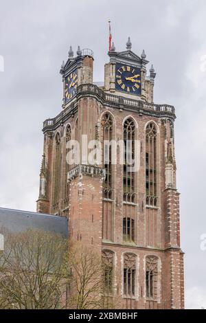 Close-up of a gothic church tower with clocks and a weather vane, dominating the cityscape, Dordrecht, holland, netherlands Stock Photo