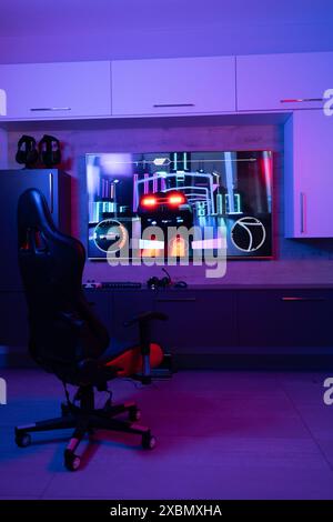 Gaming chair for video games in neon room with video streaming on screen, copy space Stock Photo