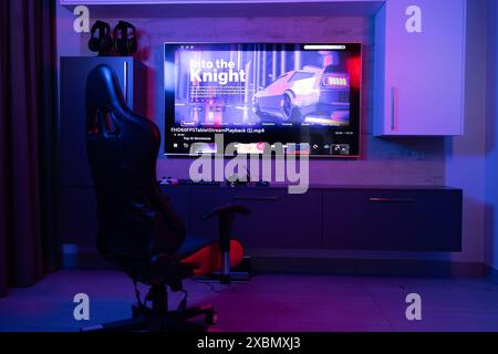 Gaming chair for video games in neon room with video streaming on screen, copy space Stock Photo