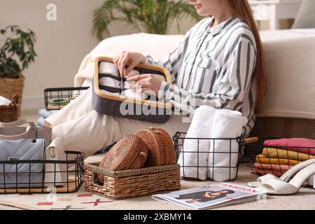 Woman with clothes and accessories in organizers at home Stock Photo