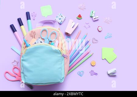 Composition with stylish school backpack and different stationery on lilac background Stock Photo