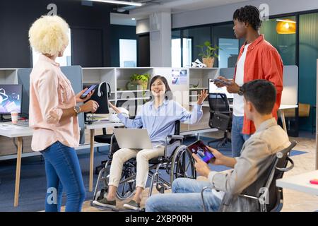 Diverse colleagues use smartphones and laptops in a modern office for business Stock Photo