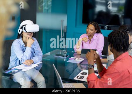 Business team collaborate in a startup, one using a VR headset, showcasing teamwork Stock Photo