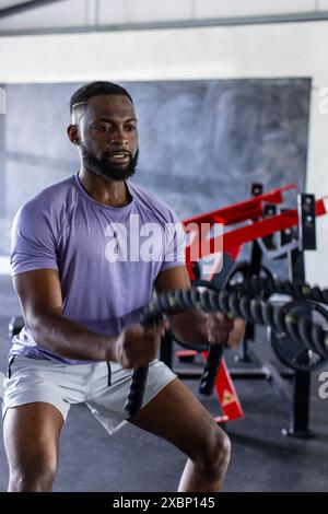 Exercising and working out, African American man using battle ropes in gym Stock Photo