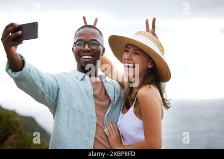Road trip, interracial couple and funny for selfie in nature, travel and countryside or vacation in Brazil. Comic, people and happy using phone for Stock Photo