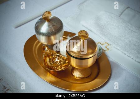 Golden chrism oil displayed on a golden tray with a golden shell for a baptism celebration Stock Photo