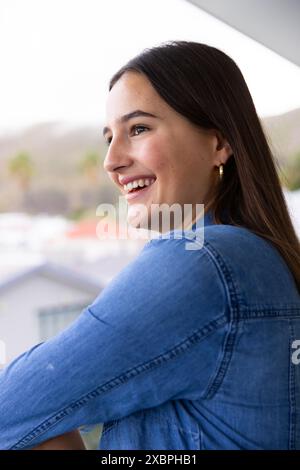 Young Caucasian woman smiling while enjoying relaxing moment at home Stock Photo
