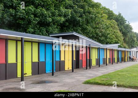 Filey, North Yorkshire, England, UK, view along the promenade or seafront at the seaside resort with colourful beach chalets on royal parade Stock Photo