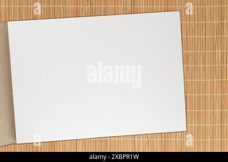 close up of white paper sheet of opened sketch book laying on bamboo mat Stock Photo