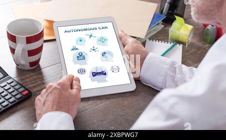 Autonomous car concept shown on a tablet held by a man Stock Photo