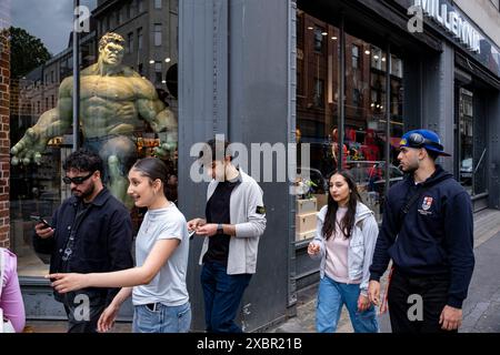 Shoppers and visitors on Oxford Street pass a the shop window of the Millennia fantasy shop which has a large scale figure of the Incredible Hulk on display on 9th June 2024 in London, United Kingdom. The Hulk is a superhero appearing in American comic books published by Marvel Comics. Oxford Street is a major retail centre in the West End of the capital and is Europes busiest shopping street with around half a million daily visitors to its approximately 300 shops, the majority of which are fashion and high street clothing stores. Stock Photo