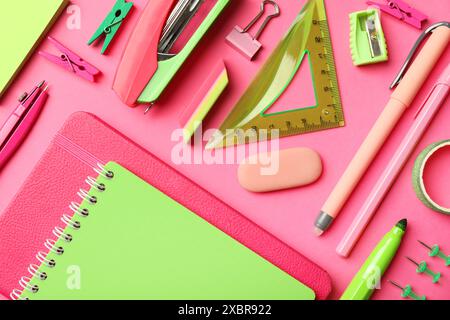 Flat lay composition with notebooks, stapler and different stationery on pink background Stock Photo