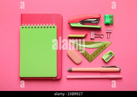 Flat lay composition with notebooks, stapler and different stationery on pink background Stock Photo