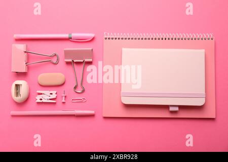 Flat lay composition with notebooks and different stationery on pink background Stock Photo