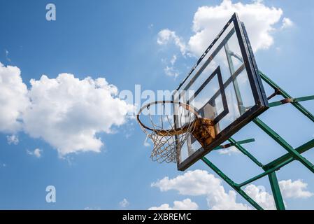 An Old Abandoned Basketball Hoop And Backboard Stands Against The Blue Sky Stock Photo