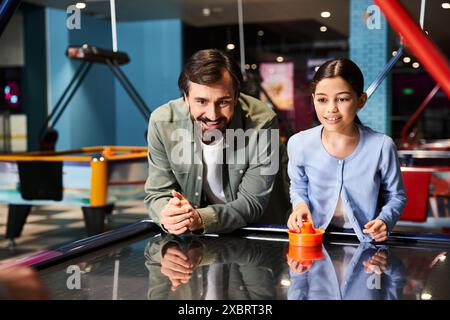 An exciting, fast-paced game of air hockey being played by father and child in a vibrant arcade setting. Stock Photo