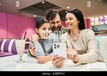 A joyful family gathers at a restaurant, happily taking a selfie together to preserve their weekend memories. Stock Photo