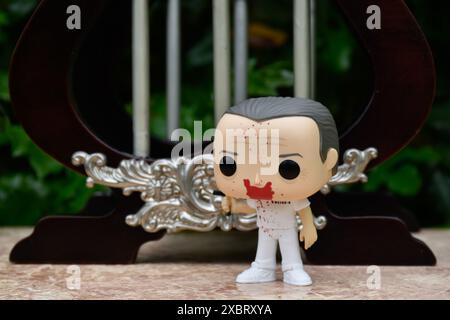 Funko Pop action figure of Hannibal Lecter from popular horror movie Silence of the Lambs. Toy standing against vintage miniature jail bars. Stock Photo