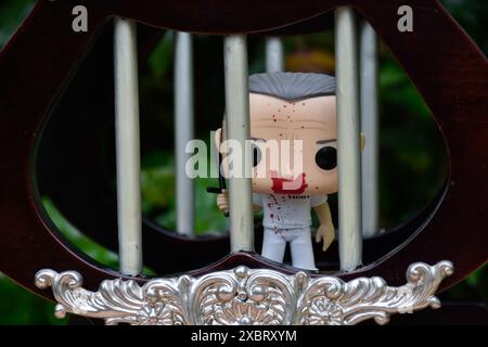 Funko Pop action figure of Hannibal Lecter from popular horror movie Silence of the Lambs. Toy prisoner standing behind vintage jail bars. Stock Photo