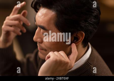 Mature Man Using Cordless Earbuds Stock Photo