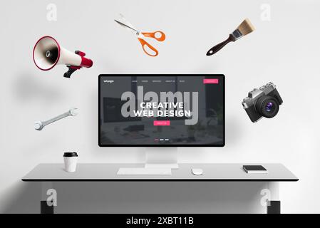 Web design studio page on display with flying concept web tools: megaphone, scissors, brush, photo camera, wrench key. Creative digital workspace visu Stock Photo