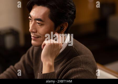 Mature Man Using Cordless Earbuds Stock Photo