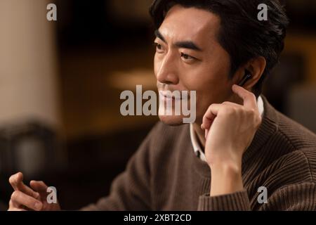 Mature Man Using Cordless Earbuds Stock Photo