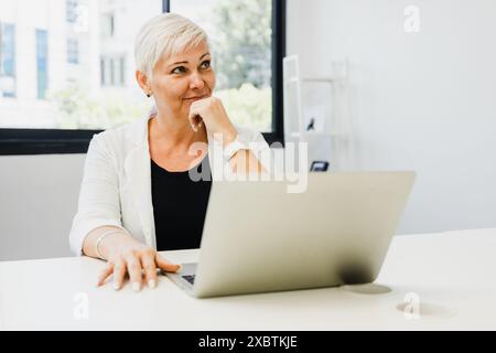 Portrait of a businesswoman working on a laptop in an office Stock Photo