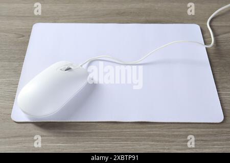 Wired mouse and mousepad on wooden table Stock Photo