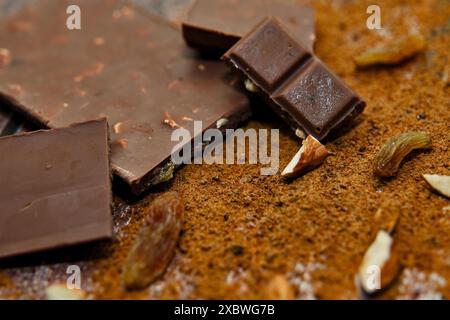 Discover the rich allure of dark chocolate bars adorned with crunchy nuts and sweet dried fruits. A gourmet delight on a rustic surface Stock Photo