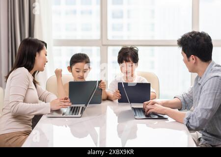 Family Using Laptops And Digital Tablets Stock Photo