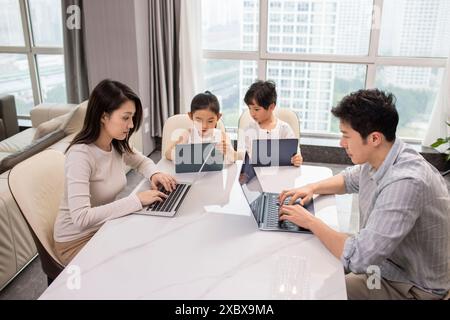 Family Using Laptops And Digital Tablets Stock Photo