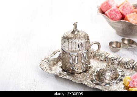 Traditional turkish coffee and turkish delight on white shabby wooden background. Stock Photo