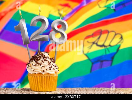 Birthday candle number 128 - Gay march flag background Stock Photo