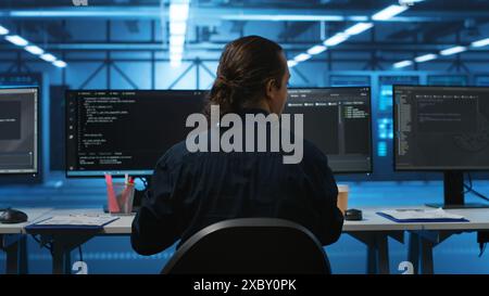 Engineer drinking coffee and programming in server room with equipment storing datasets. Employee enjoying caffeine beverage, typing code on PC to mend data center racks doing computational operations Stock Photo