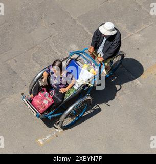 SAIGON, VIETNAM, DEC 17 2017, A man drives a tricycle with a passenger, Saigon, Vietnam Stock Photo