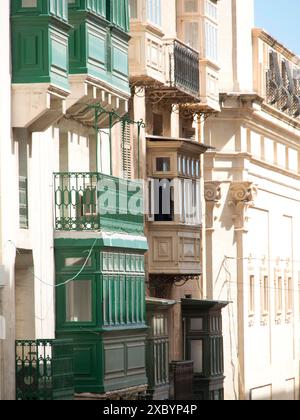 Several houses with existing wooden balconies painted in green and beige, valetta, mediterranean sea, malta Stock Photo