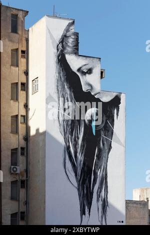 Woman with long hair looking at globe, mural in black and white by street artist INO, Athens, Greece Stock Photo
