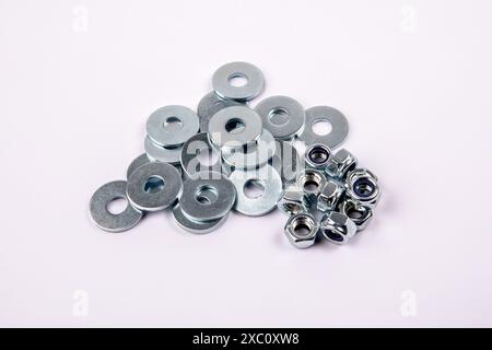 Bunch of flat washer and zinc plated hexagon nuts on white background. Stock Photo