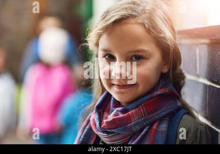 Elementary school, hallway and portrait of girl with smile for academy education, scholarship and child development. Happy, face and kid in corridor Stock Photo