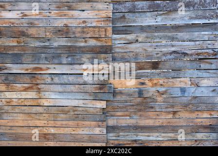 A rustic weathered horizontal backdrop wall of raw wood slats. Stock Photo