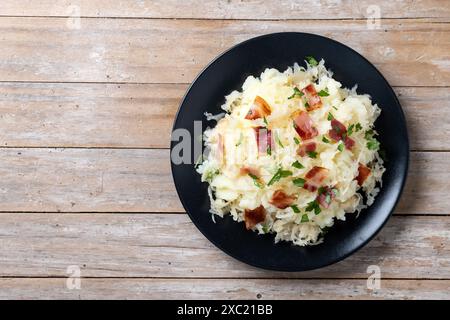 Slovak potato dumplings halusky with steamed sauerkraut and bacon on wooden table Stock Photo
