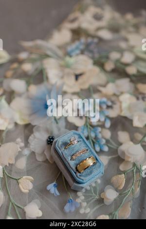 Wedding rings in blue ring box on floral veil Stock Photo