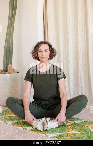 Women sitting down on yoga mat Stock Photo