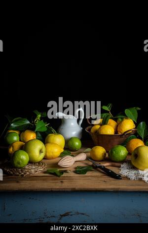 Lemons, limes and apples on rustic table with black background Stock Photo