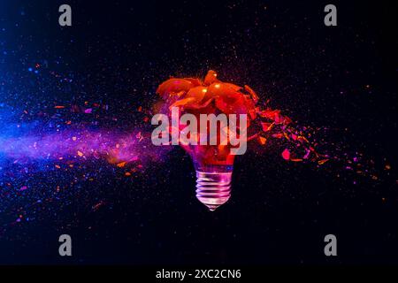 Red light bulb exploding dark background creativity crisis energy Stock Photo