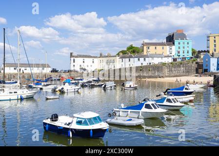 Small boats in Tenby Harbour and Tenby Harbour beach at high tide with ...